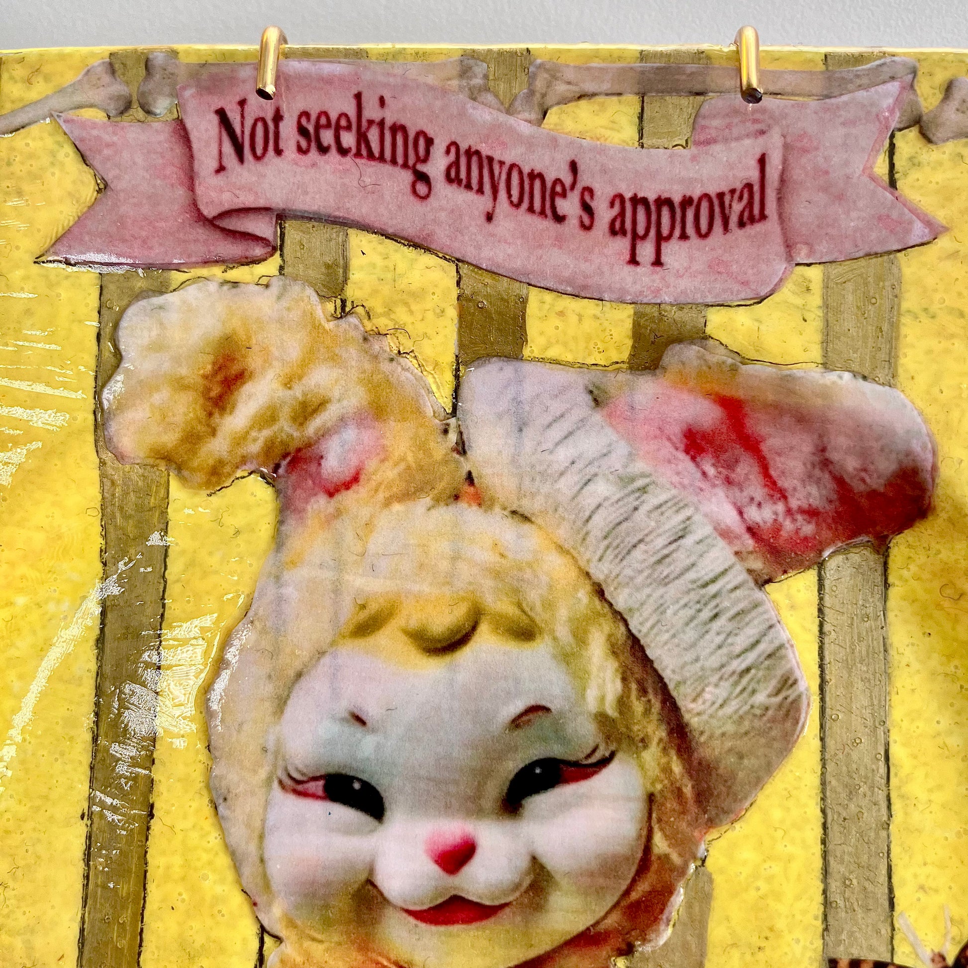 "Not Seeking Anyone's Approval" Wall Plate by House of Frisson, closeup detail of the collage showing a vintage bunny toy against a yellow and gold background.
