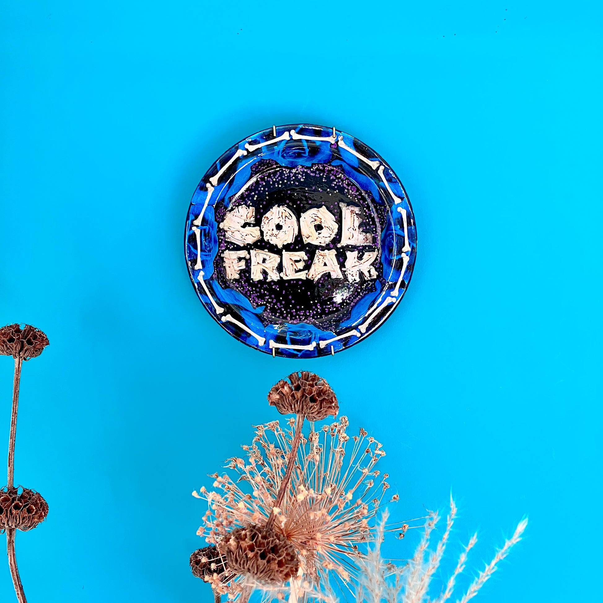 "Cool Freak" Wall Plate by House of Frisson lifestyle photo of the plate hanging on a blue wall.