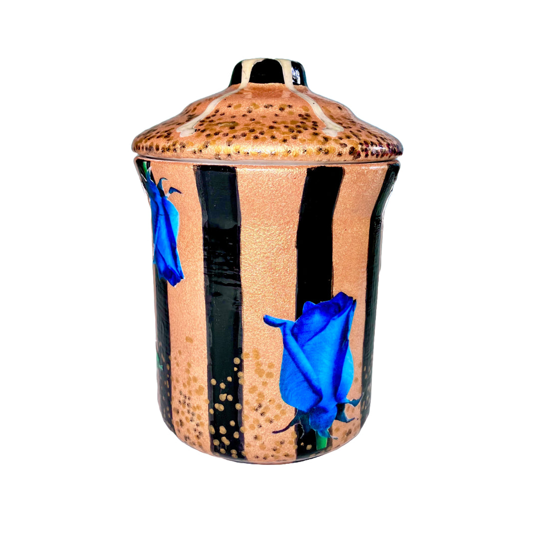 Gold Upcycled Jar by House of Frisson, featuring a collage of blue roses, bones, and a lizard, on a background of gold and black stripes. 