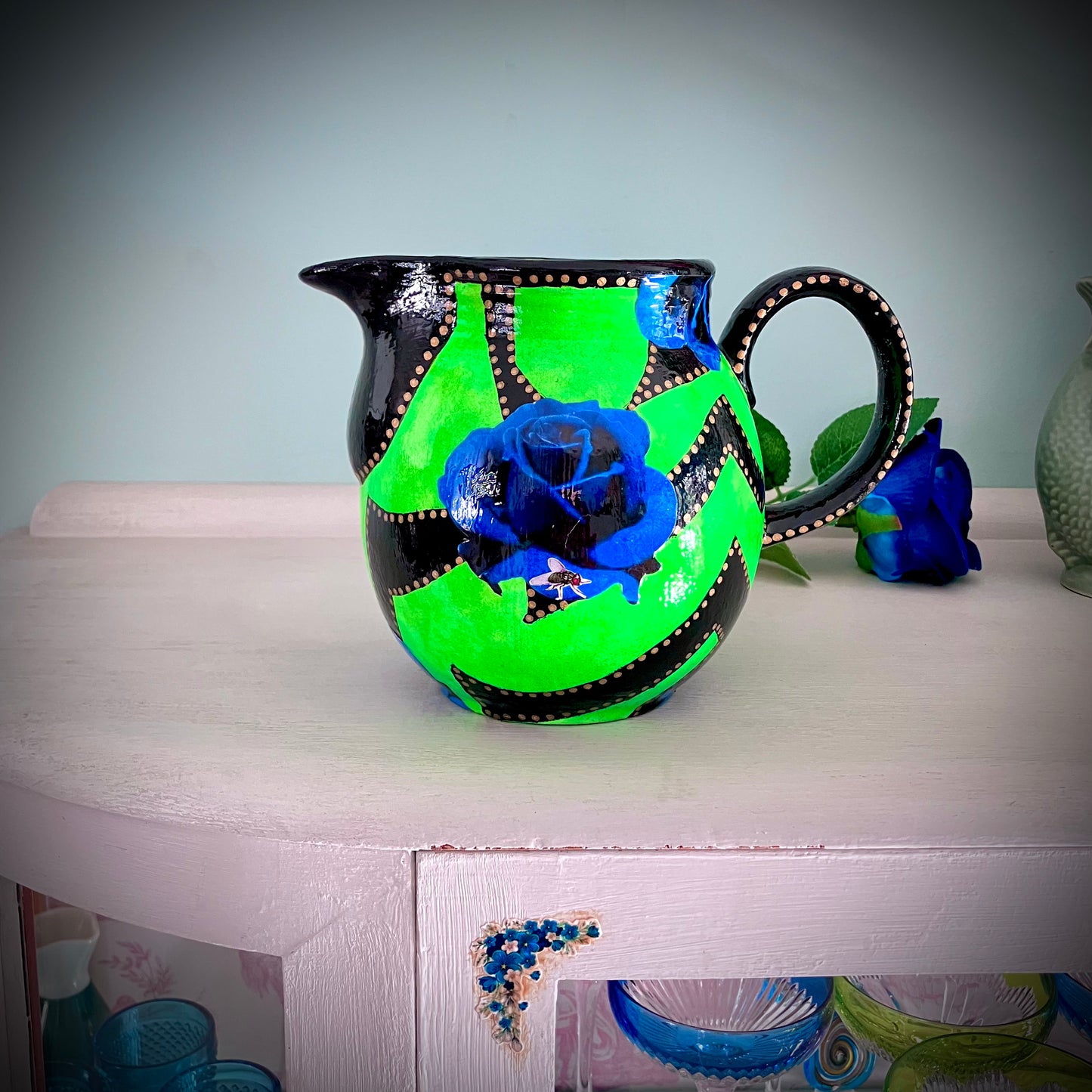 Neon Green upcycled Pitcher/Vase by House of Frisson, featuring some graphics in black and blue roses, beautifully contrasting with the bright green background.