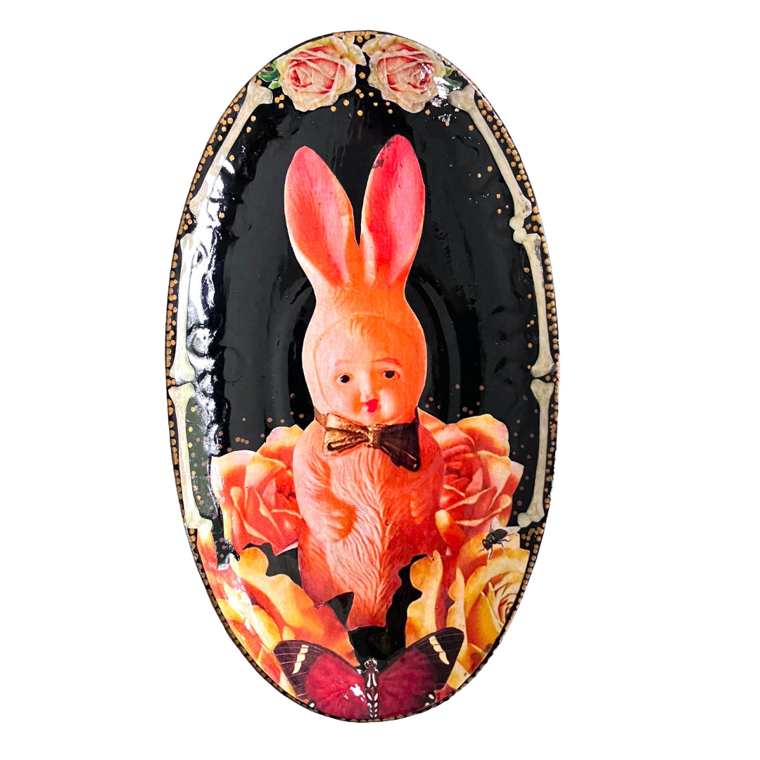 Black upcycled wall plate by House of Frisson, featuring a kitsch vintage squeaky bunny image surrounded by roses and bones.