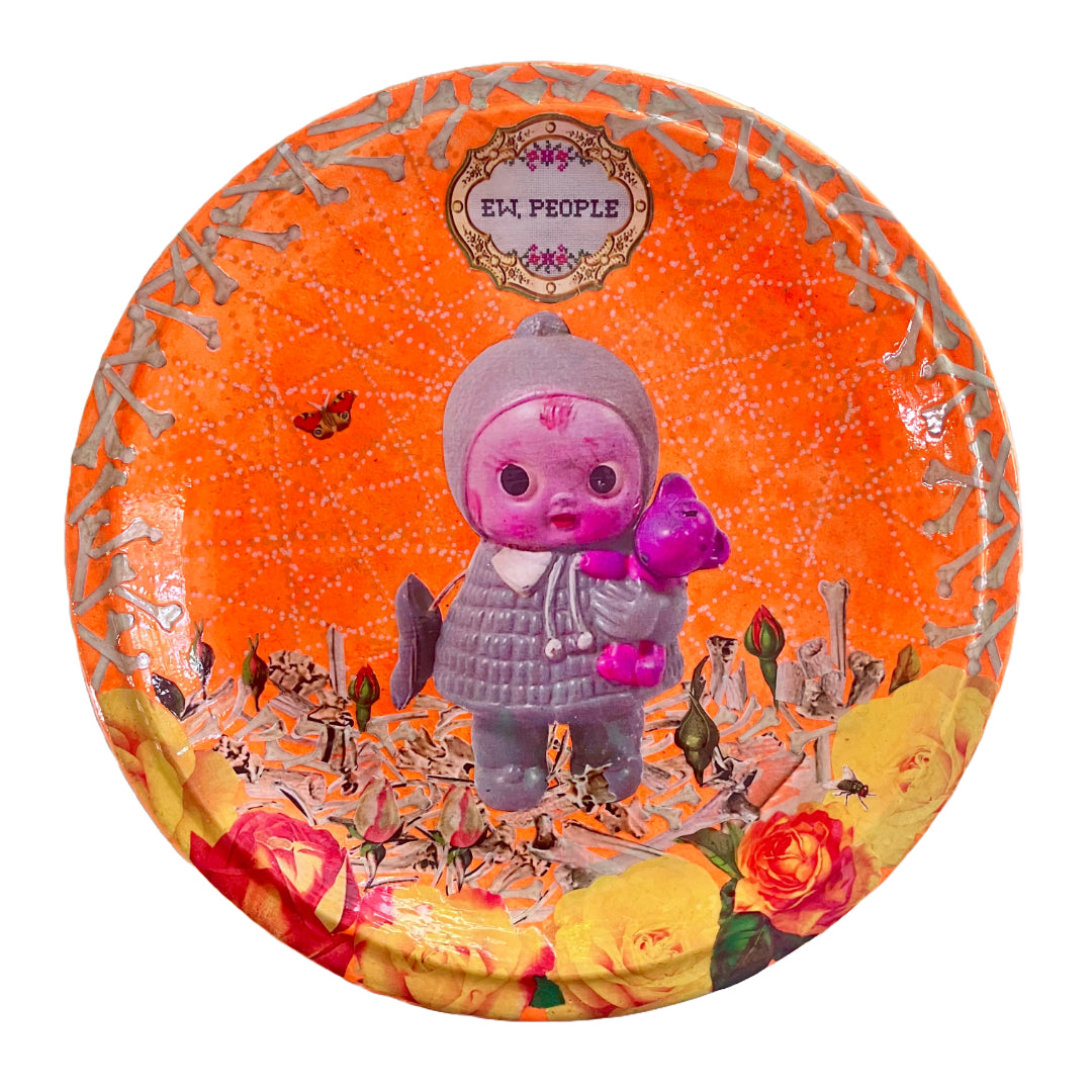 Neon orange wall plate by House of Frisson, featuring a vintage doll surrounded by bones and flowers, this plate exclaims "Ew, People" to poke fun at those who find dolls creepy.