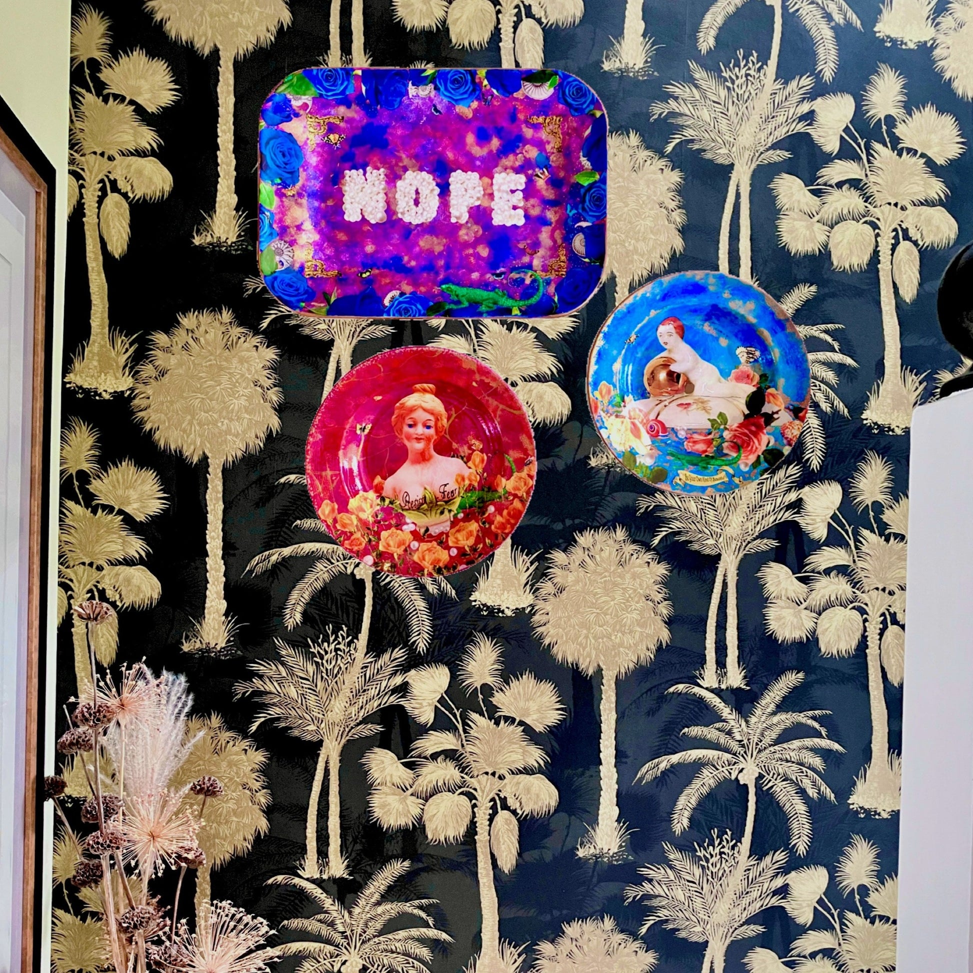 "Nope" Wall Plate by House of Frisson. Featuring the word "nope" written with pearls, framed by blue roses, shells, moths, and a lizard, on a  purple, blue and golden background. Lifestyle photo of plate on a wall with other plates.