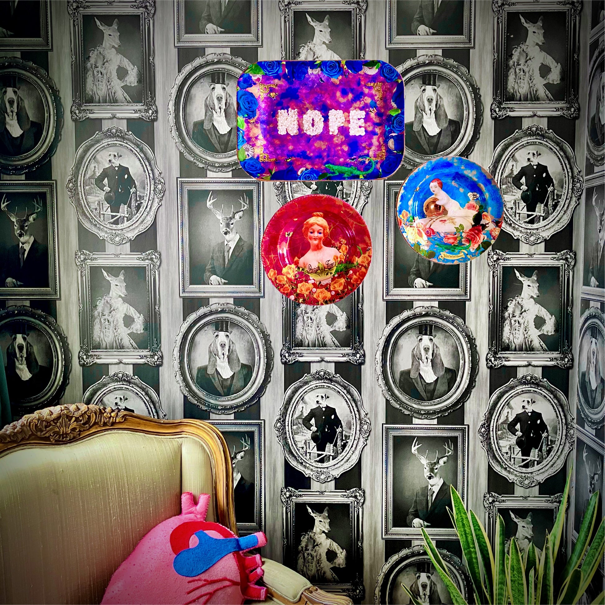"Nope" Wall Plate by House of Frisson. Featuring the word "nope" written with pearls, framed by blue roses, shells, moths, and a lizard, on a  purple, blue and golden background. Lifestyle photo of plate on wall with other plates.