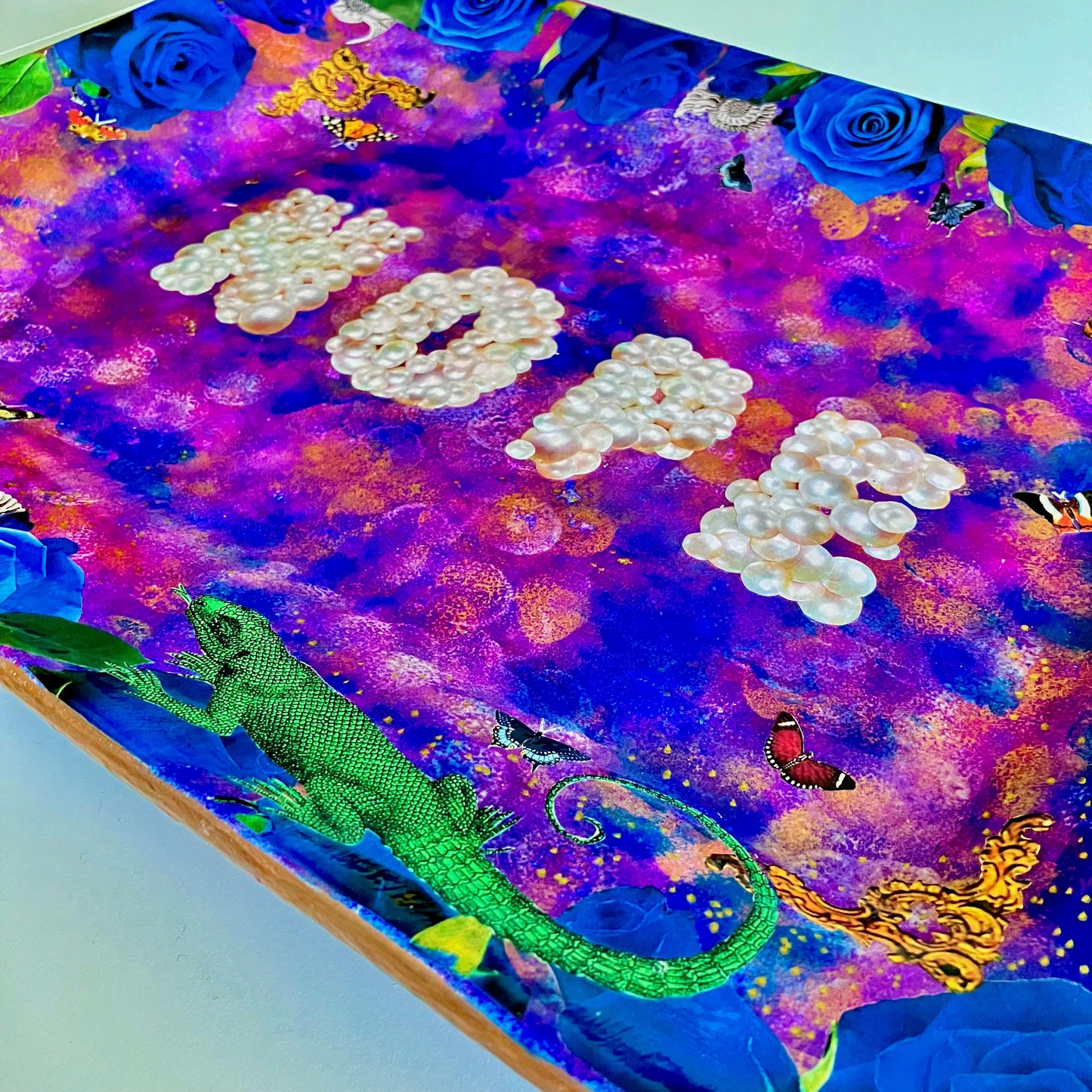 "Nope" Wall Plate by House of Frisson. Featuring the word "nope" written with pearls, framed by blue roses, shells, moths, and a lizard, on a  purple, blue and golden background. Closeup details showing blue roses, moths, and a lizard.