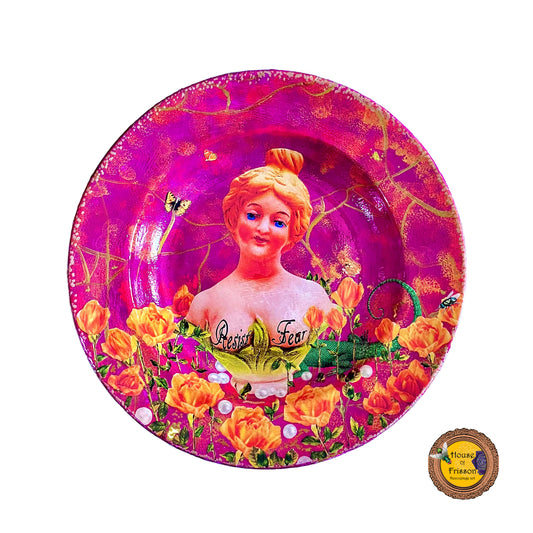 "Resist Fear" Wall Plate by House of Frisson, featuring a female bust statue with "Resist Fear" written across breasts, surrounded by flowers, and pearls, on a purple background.