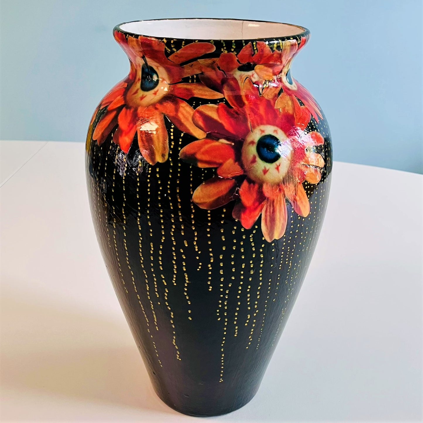 "Starey Flowers" Flower Vase by House of Frisson, featuring a collage of flowers with eyeballs, on a black background. Different angle of the vase.