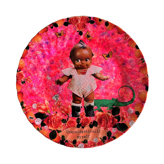 "Unapologetically Myself" Wall Plate by House of Frisson, featuring a vintage black doll surrounded by roses , pearls, moths, and a lizard, framed by shells, on a pink background.