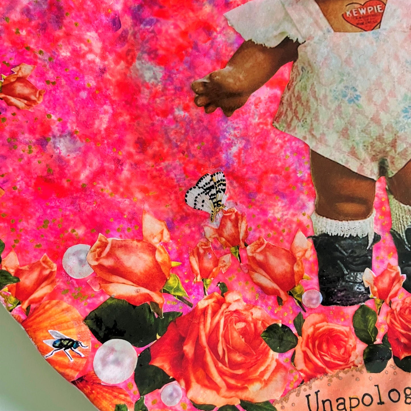 "Unapologetically Myself" Wall Plate by House of Frisson, featuring a vintage black doll surrounded by roses , pearls, moths, and a lizard, framed by shells, on a pink background. Showing closeup details of the roses, pearls, and moths.