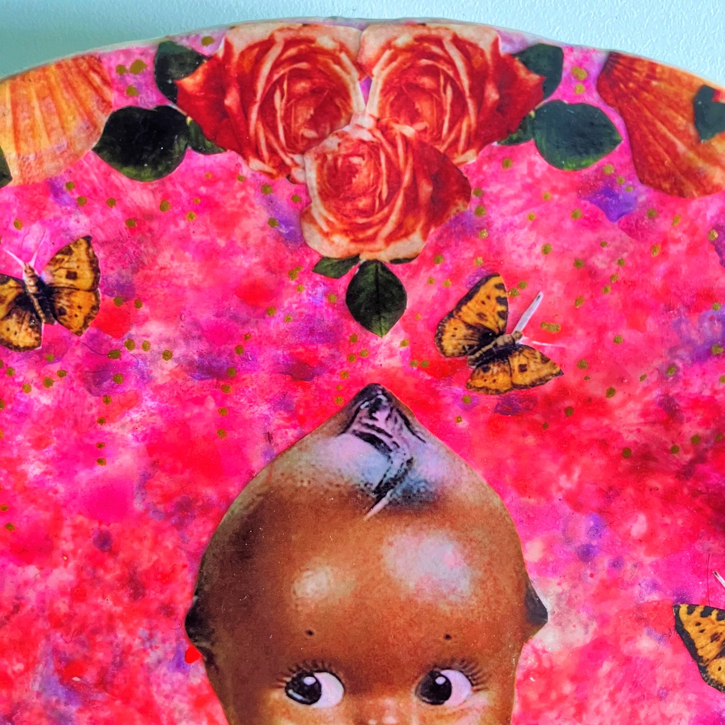 "Unapologetically Myself" Wall Plate by House of Frisson, featuring a vintage black doll surrounded by roses , pearls, moths, and a lizard, framed by shells, on a pink background. Showing closeup details of the doll, moths and roses.