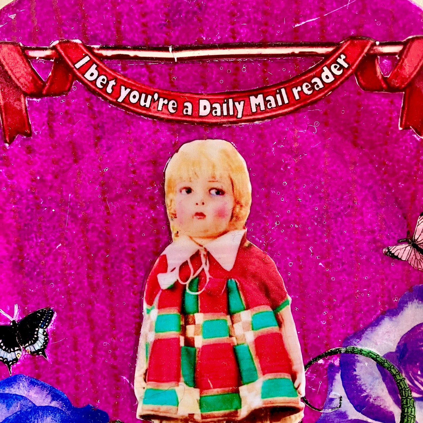 "I Bet You're A Daily Mail Reader" Wall Plate by House of Frisson, closeup detail of the collage showing a vintage doll, on a purple background.