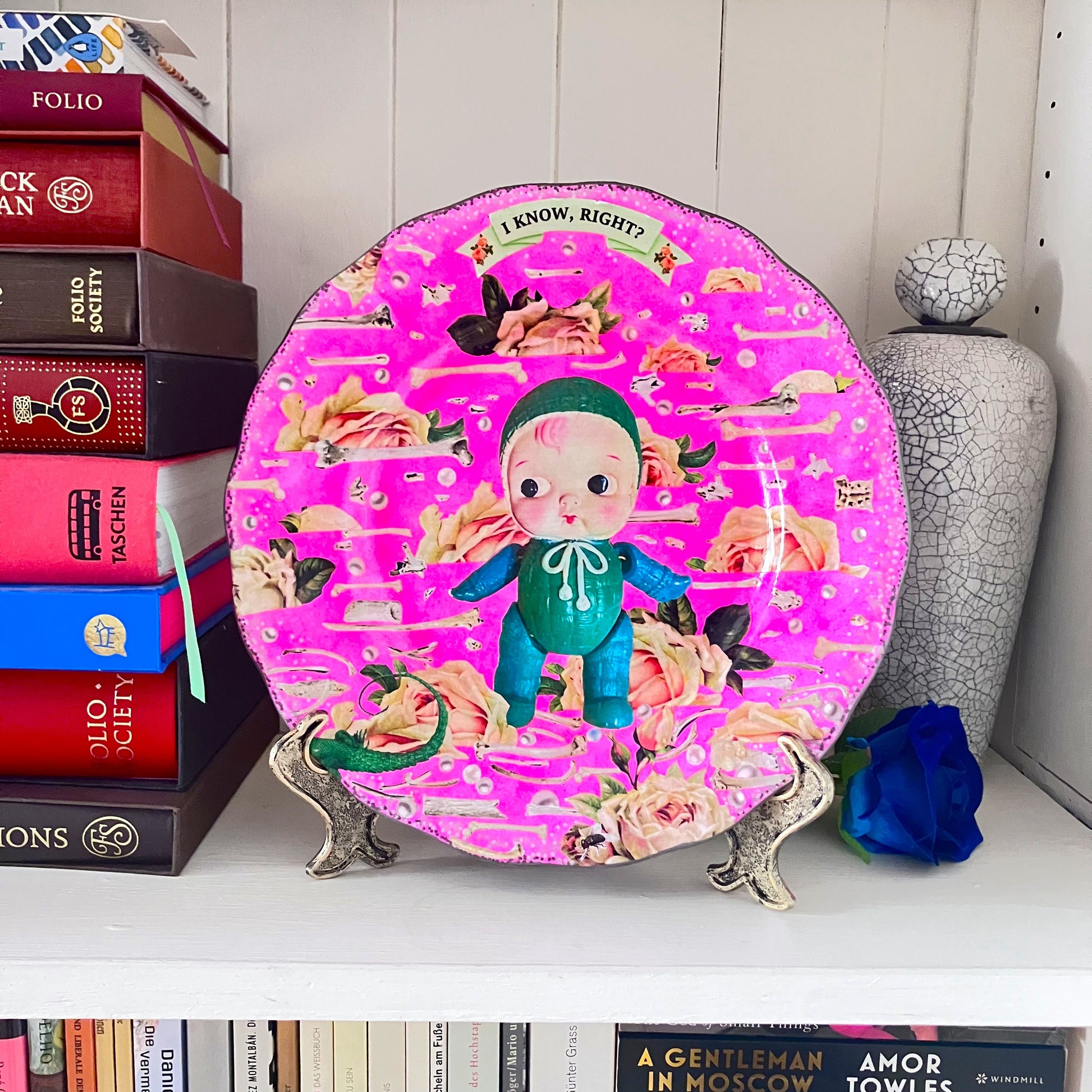 Neon Pink Upcycled Wall Plate featuring a collage of a vintage celluloid doll on a pattern of roses, bones, and pearls. 