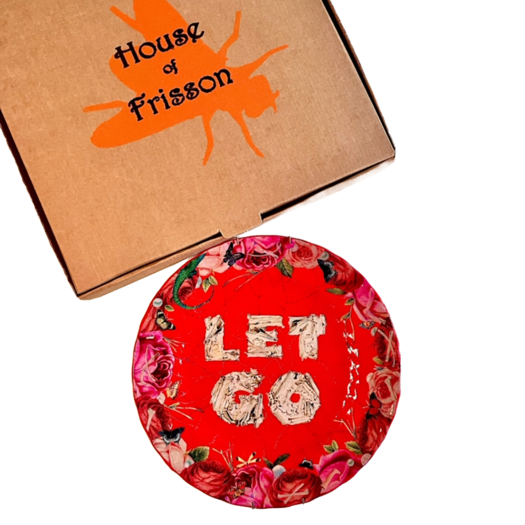 "Let Go" Wall Plate by House of Frisson next to House of Frisson's branded box.