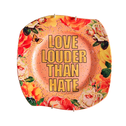 "Love Louder Than Hate" Upcycled Wall Plate by House of Frisson, featuring a collage of the words "love louder than hate" set against a peach background and framed by roses.