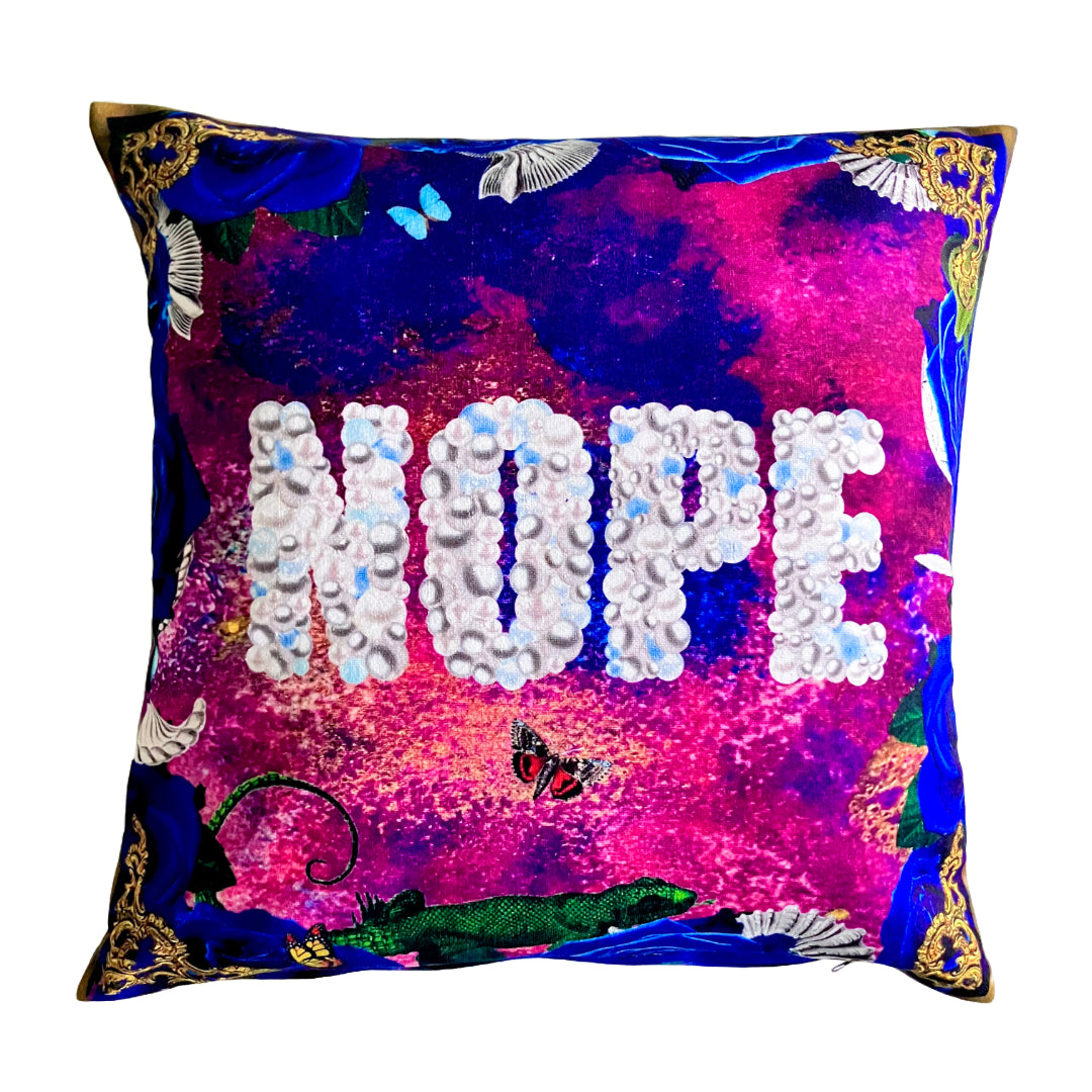 "Nope" Cushion Cover by House of Frisson. Featuring the word "Nope" written with pearls, framed by blue roses, and shells, against a blue and purple background.