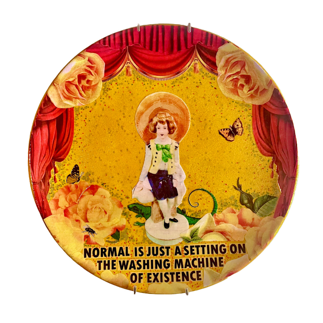 "Normal Is Just A Setting On The Washing Machine Of Existence" Wall Plate by House of Frisson, featuring a collage artwork of a kitsch porcelain figure surrounded by roses, a lizard, and moths, framed by red curtains on a yellow background.