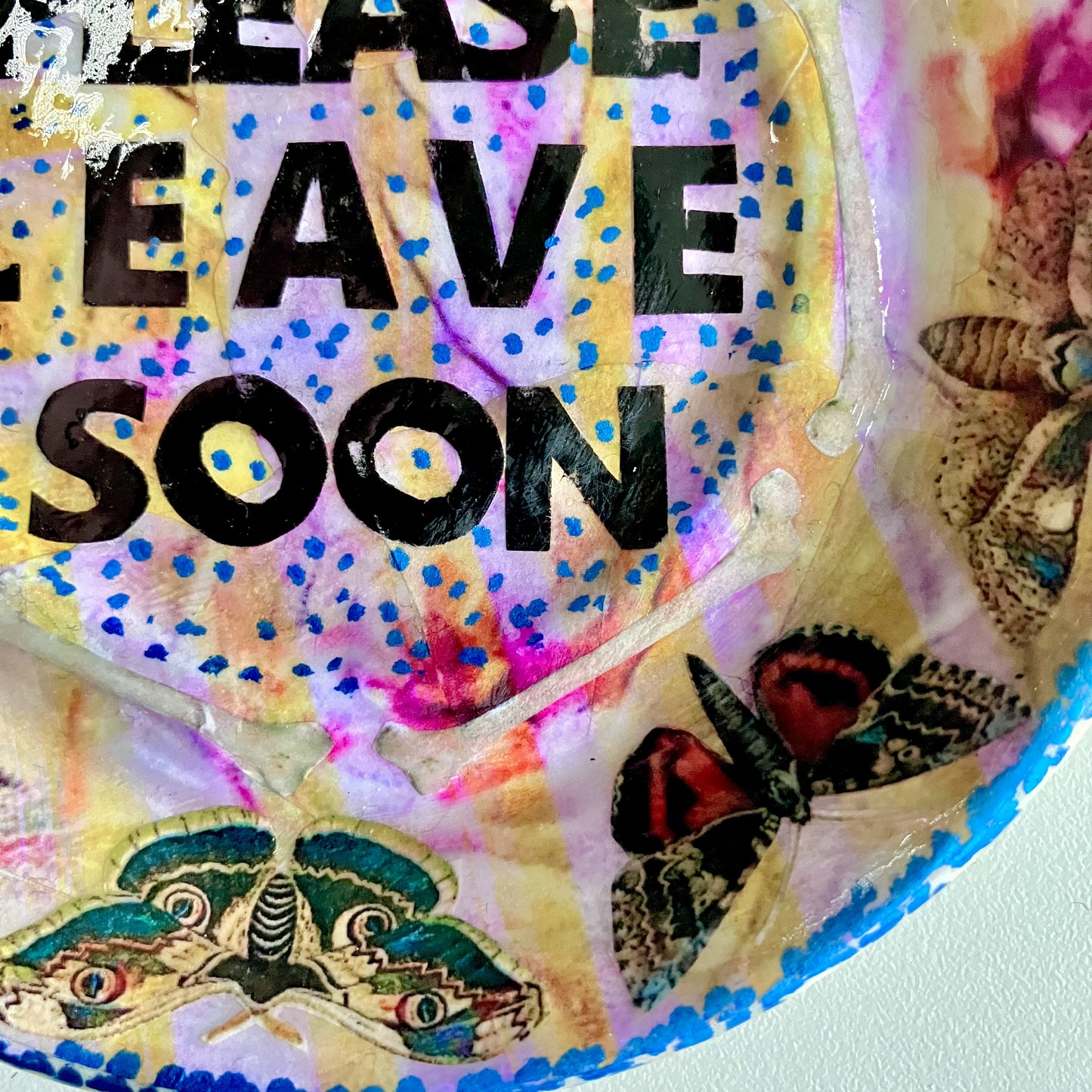 "Please Leave Soon" Trinket Dish by House of Frisson. Featuring some moths and the words "please leave soon", on yellow and pink background. Closeup detail showing moths, and bones.