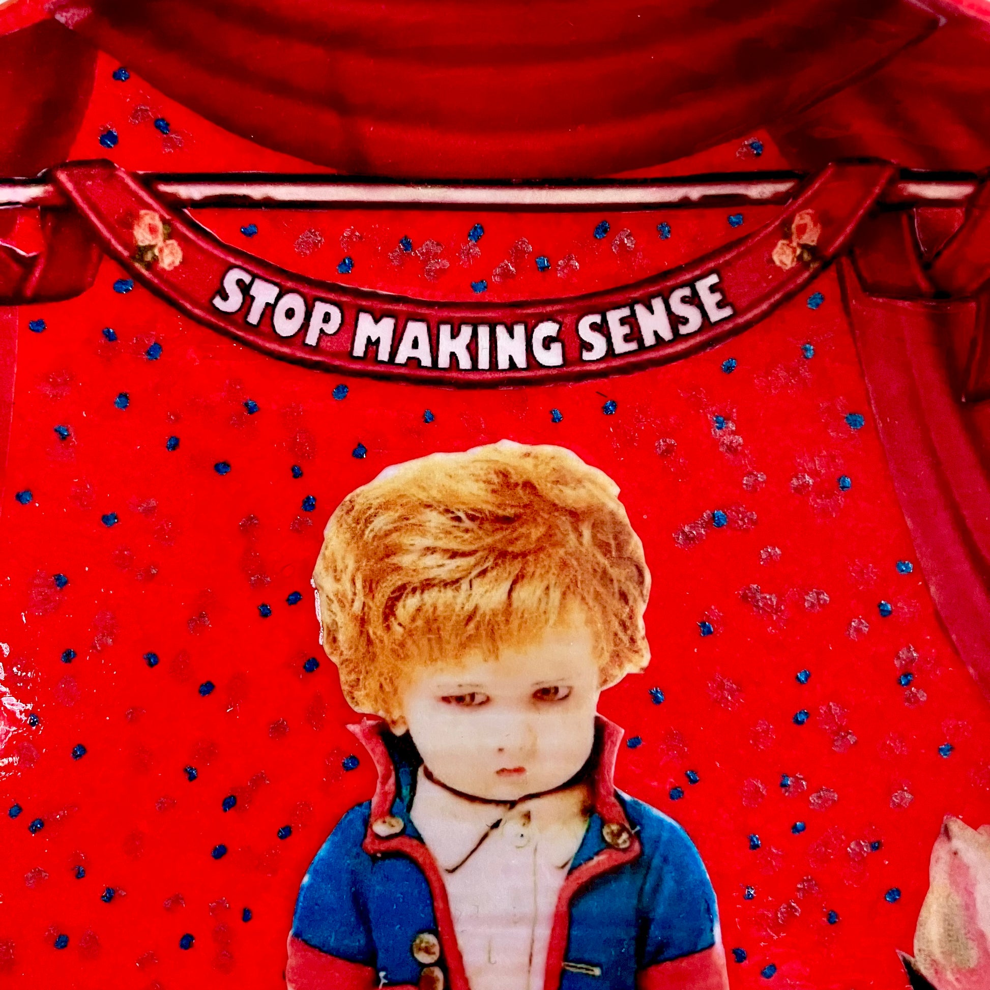 "Stop Making Sense" Wall Plate by House of Frisson, closeup detail of the collage showing a felt male doll and red curtains.