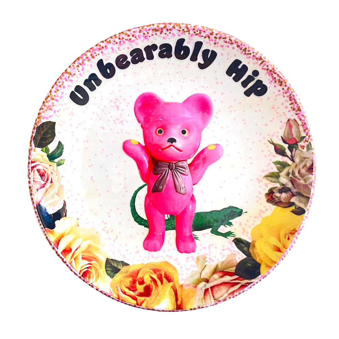 White Upcycled Wall Plate featuring a kitschy pink bear surrounded by whimsical creatures and roses, making it "Unbearably Hip."