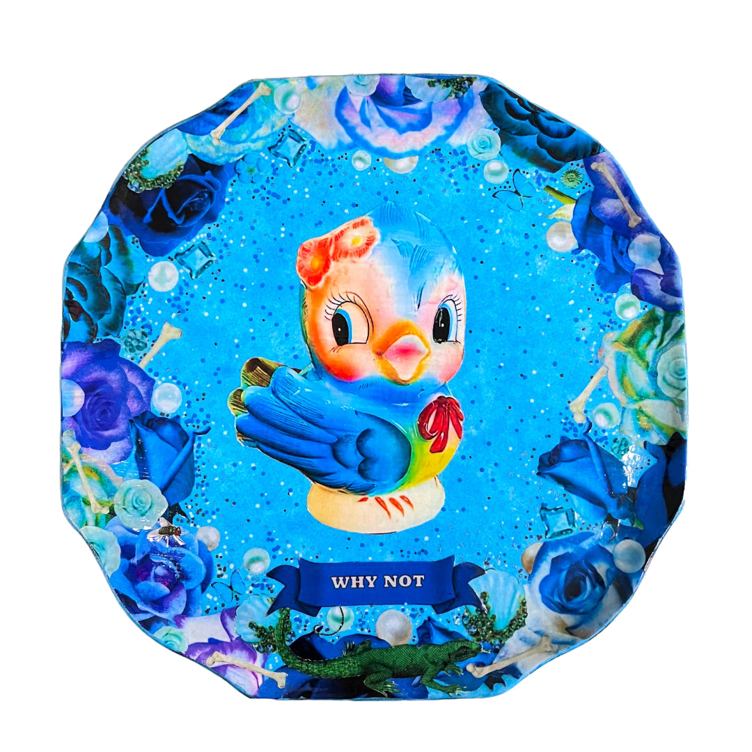 Blue upcycled wall plate by House of Frisson featuring a collage of a vintage ceramic bird image with blue roses, pearls, and bones.