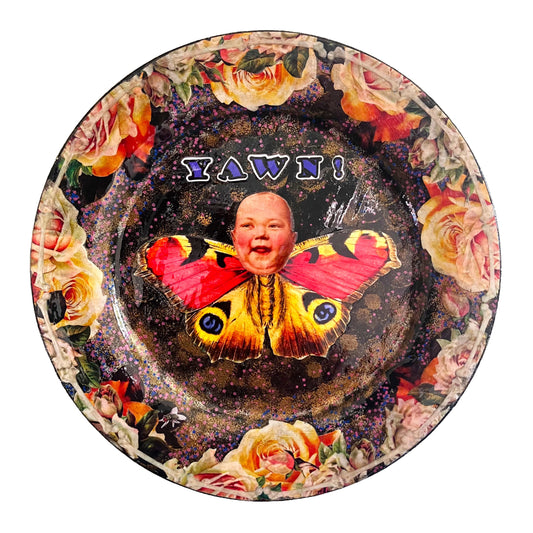 Upcycled Wall Plate by House of Frisson. Featuring a unique collage of a moth with a doll face, surrounded by delicate roses and bones, this quirky piece is anything but ordinary.